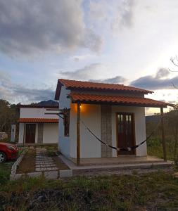 una pequeña casa con un coche aparcado delante de ella en Canto Ybykuara - Natural Guest House en Ibicoara