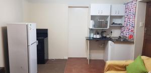 a small kitchen with a refrigerator and a counter at Neat Haven Self Catering in Grahamstown