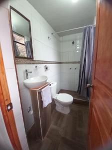 a bathroom with a sink and a toilet and a mirror at Secret Valley House Cusco in Ollantaytambo