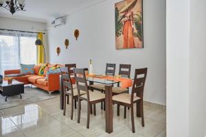 - une salle à manger avec une table, des chaises et un canapé dans l'établissement Ravissant appartement 2ch à la plage, à Pointe-Noire