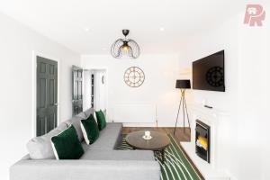 Birmingham 4 Bedroom Home - Driveway & Garden - Brand New! في برمنغهام: غرفة معيشة مع أريكة ومدفأة