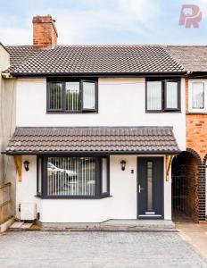 a white house with black windows and a driveway at Birmingham 4 Bedroom Home - Driveway & Garden - Brand New! in Birmingham