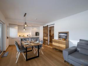kuchnia i salon ze stołem i kanapą w obiekcie Ferienwohnung Tirolglück mit großem Garten w mieście Sankt Johann in Tirol