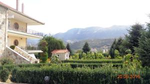 a house with a garden in front of a mountain at VALIA ROOMS in Kalavrita