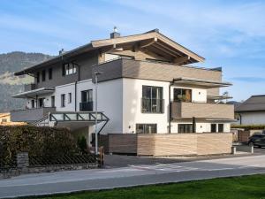duży biały dom z dachem naczółkowym w obiekcie Ferienwohnung Tirolglück mit großem Garten w mieście Sankt Johann in Tirol