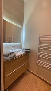 een badkamer met een wastafel en een spiegel bij By nuit-parisienne : Superbe appartement avec SPA et terrasse privée in Villemomble