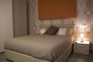 フィウミチーノにあるハッピー ホームのベッドルーム1室(ベッド1台、ランプ付きのナイトスタンド付)