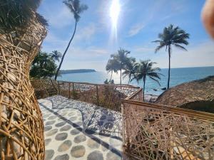 uma vista para o oceano a partir de uma praia com palmeiras em Obrigado by Craftels em Cabo de Rama