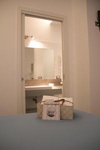 a bathroom with a sink and a mirror and a box at Happy Home in Fiumicino