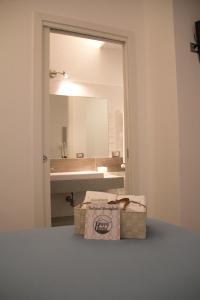 La salle de bains est pourvue d'un lavabo, d'un miroir et d'une boîte. dans l'établissement Happy Home, à Fiumicino