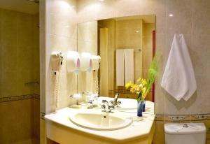 a bathroom with a sink and a mirror and a toilet at Aqua Hotel in Varna City
