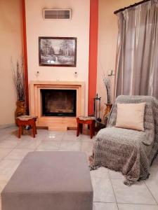 a living room with a chair and a fireplace at Το σπίτι του Γιάννη in Pýli