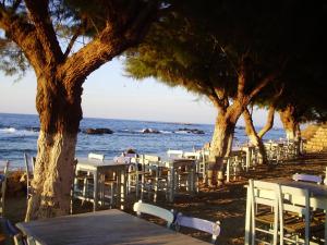 a group of tables and chairs on the beach at Melani Apartments in Chania