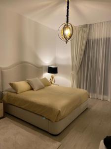 Schlafzimmer mit einem Bett mit einer Lampe und Vorhängen in der Unterkunft MJL Rahaal2- 301Apartament in Dubai