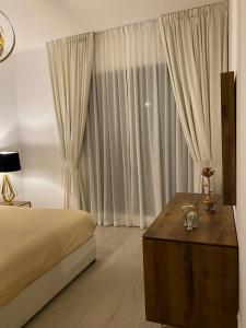 MJL Rahaal2- 301Apartament في دبي: غرفة نوم بسرير وطاولة عليها قطة