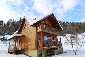 ein Blockhaus im Schnee mit Schnee in der Unterkunft Котедж "Карпатський Краєвид" in Jaremtsche