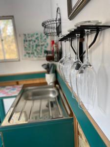 a row of wine glasses hanging on a kitchen counter at Viewpoint Country Glamping in Great Western