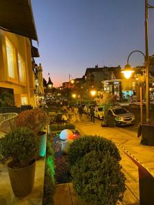 una calle de la ciudad por la noche con coches y gente en Apto Pátio Goods Br (café da manhã incluso), en Gramado