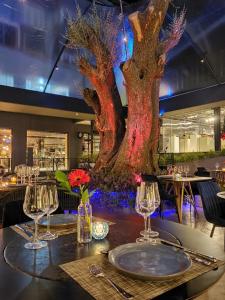 a table in a restaurant with a large tree on the wall at Apto Pátio Goods Br (café da manhã incluso) in Gramado