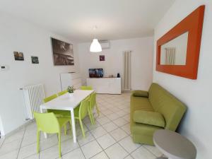 a living room with a green couch and a table at Case vacanza Erica Igea Marina in Bellaria-Igea Marina