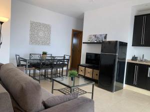 a living room with a couch and a table and a kitchen at Ed Senses Apartamento Freedom in Tarifa