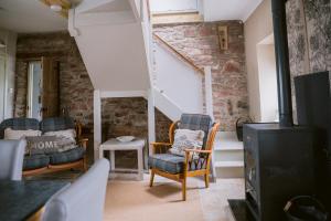 a living room with chairs and a staircase at Dunruadh Cottage in Gartocharn