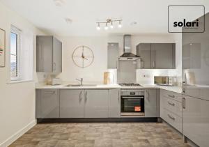 a kitchen with white cabinets and a stove top oven at Lux 4 Bed Contractor x Relocator Apartment, 30 Percent Off Monthly Stays, FREE Multiple Parking Spaces, Super Fast WiFi, Streaming Services included, Close to A1 in Peterborough +5 photos