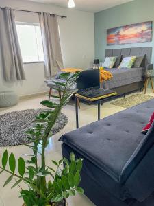 a living room with a couch and a laptop on a table at Mangata Loft - Requinte e Conforto para Lazer ou Trabalho in Itanhaém