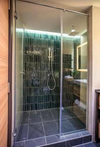 a bathroom with a shower with green tiles at Woodside Duplex Apartment Ski in Ski out with garage in Kopaonik