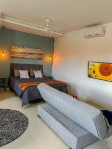 a bedroom with a bed and a couch at Mangata Loft - Requinte e Conforto para Lazer ou Trabalho in Itanhaém