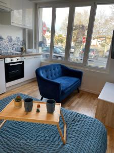 sala de estar con sofá azul y mesa en Le Marin, à 500m du centre ville, en Dax