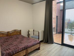 um quarto com uma cama e uma grande janela em Villa 15 , Ambassadori Kachreti Golf Resort em Kachretʼi