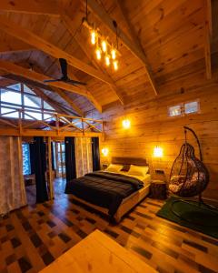 - une chambre avec un lit dans une cabane en bois dans l'établissement Wolfandwoods, à Khajjiar 
