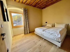 um quarto com uma cama e uma janela em La casina di Vigo em Ton