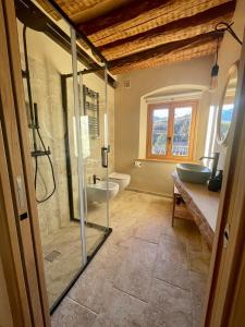 uma casa de banho com uma cabina de duche em vidro e um lavatório. em La casina di Vigo em Ton