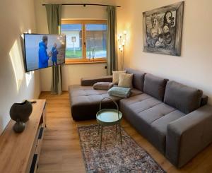 a living room with a couch and a flat screen tv at Apart Smart in Bruck am Ziller