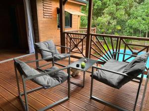 twee stoelen en een tafel op een terras bij La kaz à pépés, charmant logement avec piscine in Lamentin