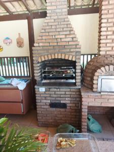 an outdoor brick oven in a room with a table at Apartamento em guarajuba 200m da praia in Camaçari