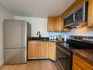 uma cozinha com um frigorífico branco e armários de madeira em Cheerful Designer Condo w/ City & Mountain Views em Sandy