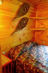 una camera da letto con un letto in una parete di legno di Wild Fox Cabins a The Pines