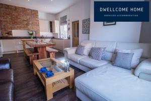 uma sala de estar com um sofá e uma mesa em Dwellcome Home Ltd 5 Double Bedroom 6 Beds Townhouse 2 Bathrooms - see our site for assurance em South Shields