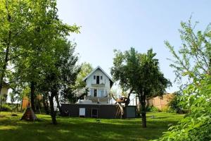 uma casa branca com um quintal com árvores em House with hot tub, sauna and swimming pool near Zagreb em Gudci