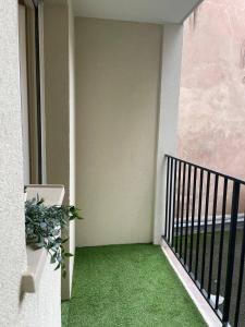 einen Balkon mit grünem Gras an der Seite eines Gebäudes in der Unterkunft Cozy Appartement Halles Strasbourg in Straßburg