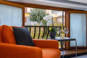 een woonkamer met een oranje bank en een tafel bij La Perla del Lario 51 in Bellagio