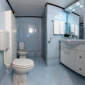 een witte badkamer met een toilet en een wastafel bij La Perla del Lario 51 in Bellagio