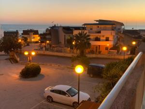 um carro estacionado num parque de estacionamento ao pôr-do-sol em Villa Andromeda apartments em Realmonte