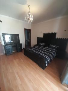 - une chambre avec un lit noir et une cheminée dans l'établissement Marina Agadir appartement, à Agadir