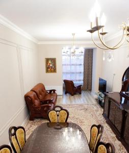 ein Wohnzimmer mit Tisch und Stühlen in der Unterkunft Исы Байзакова 131, новостройка in Pawlodar