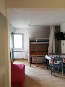 a small room with a bed and a table in it at Studio Pla d'Adet in Saint-Lary-Soulan