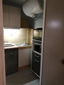 a small kitchen with a sink and a microwave at Studio Pla d'Adet in Saint-Lary-Soulan